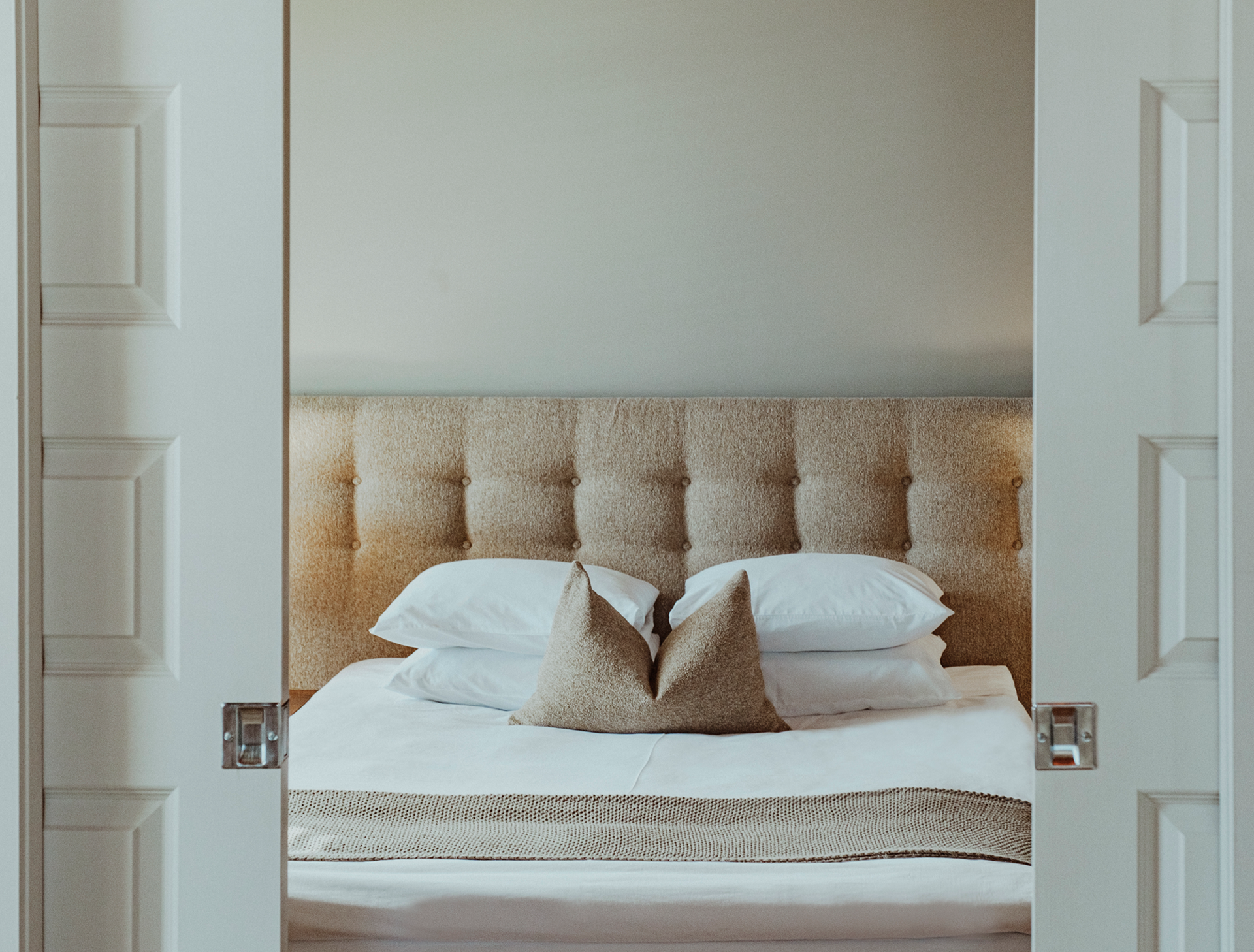 Une chambre d'hôtel avec un lit et deux portes coulissantes ouvertes.