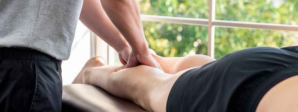 A Person is Getting a Massage on Their Leg in Front of a Window — Your Body Revolution in Caloundra, QLD