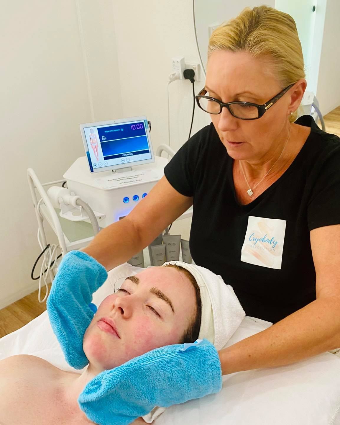 A Woman is Giving a Woman a Facial Treatment With a Towel on Her Head — Your Body Revolution in Caloundra, QLD
