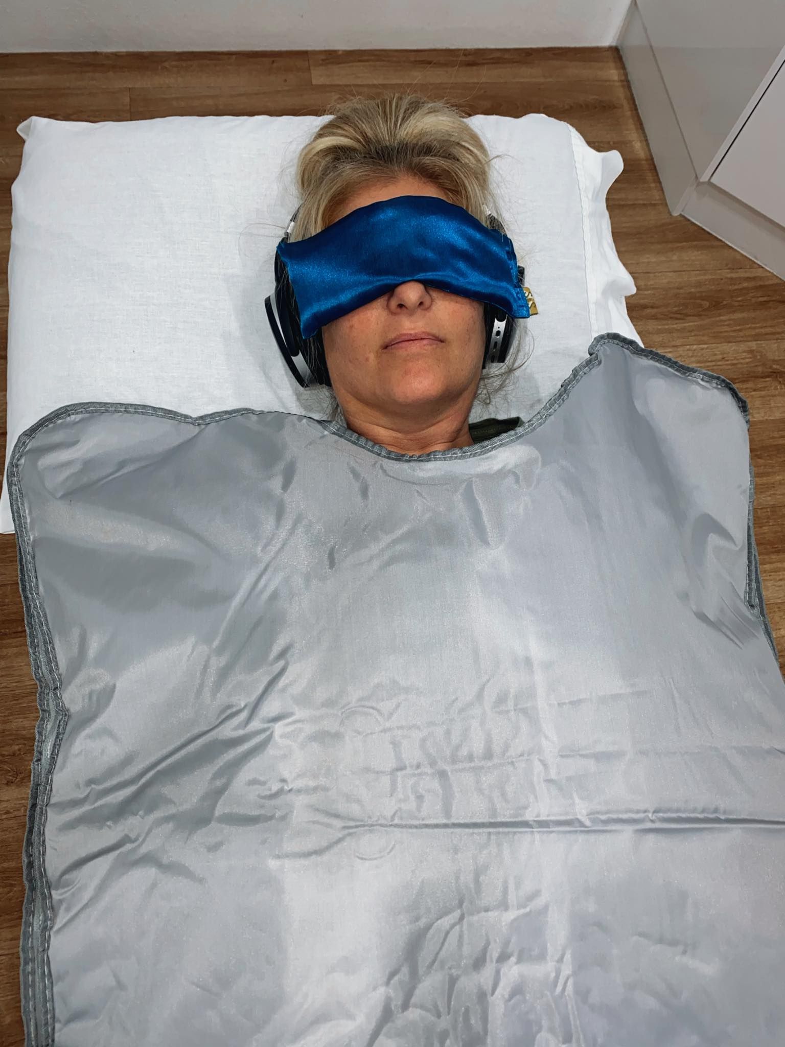 A Woman is Laying in a Blanket With a Blue Eye Mask and Headphones on Her Head — Your Body Revolution in Caloundra, QLD