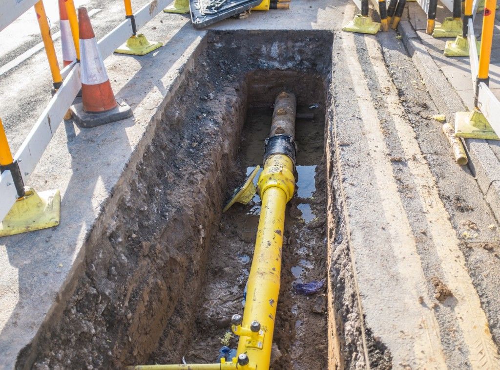 A man is working on a pipe with a wrench.