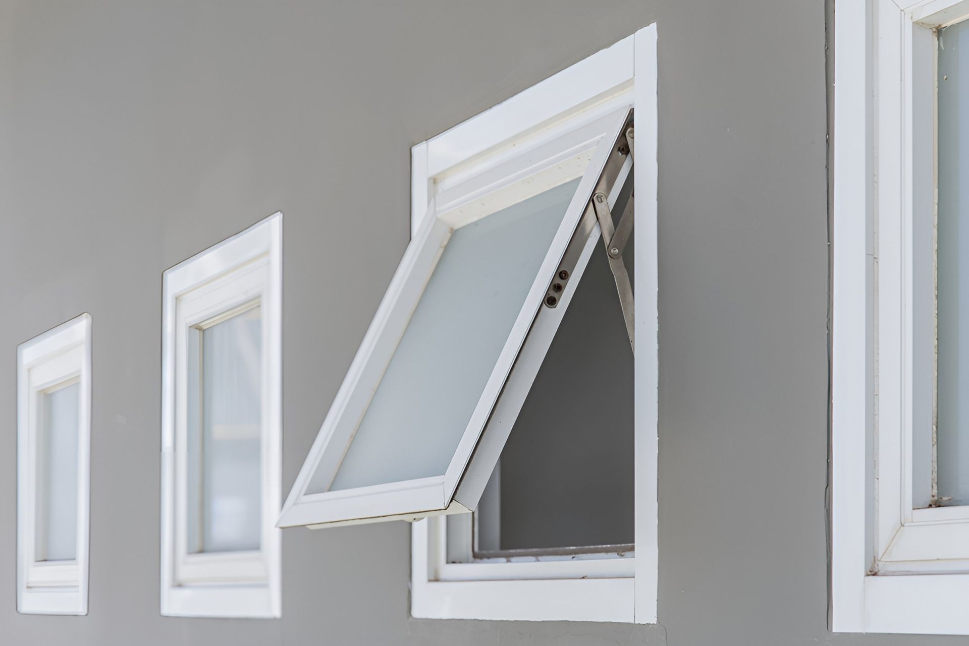 A Row Of White Windows On A Gray Wall With One Window — K & S Windows In Ciccone, NT