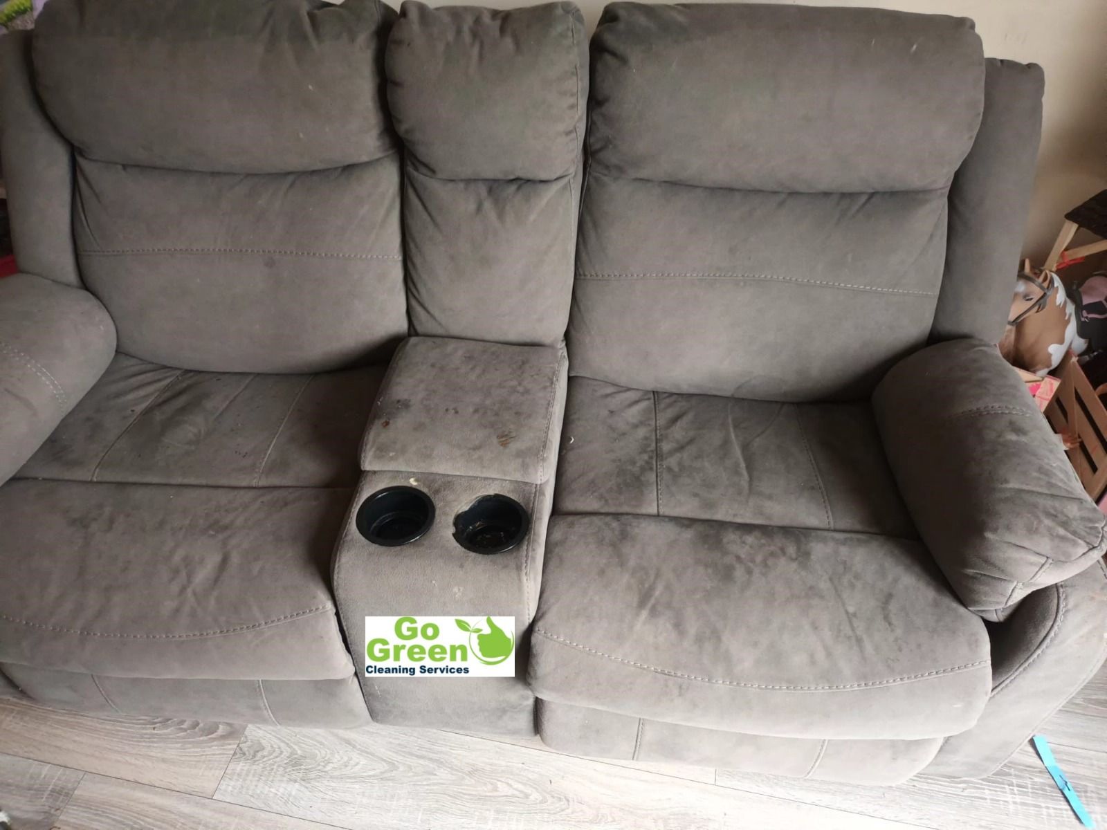 Gray reclining loveseat with cup holders.