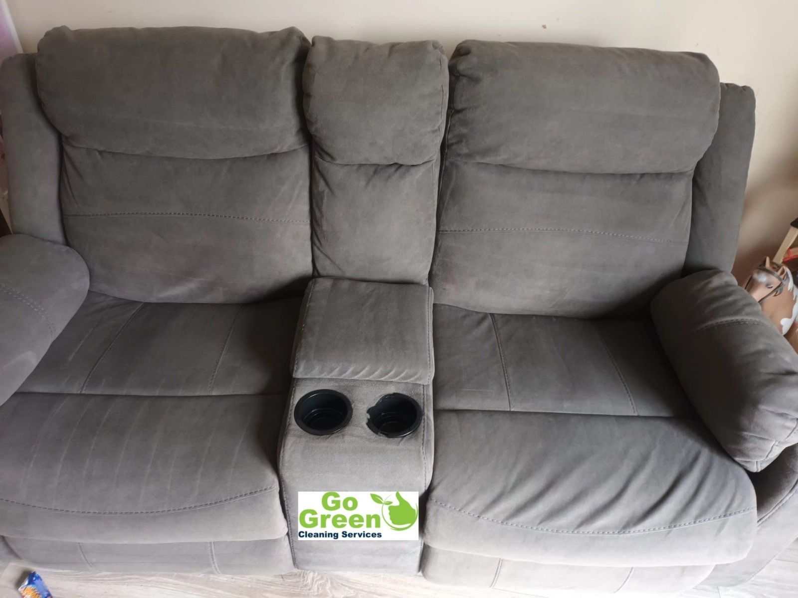 Gray reclining sofa with cup holders.