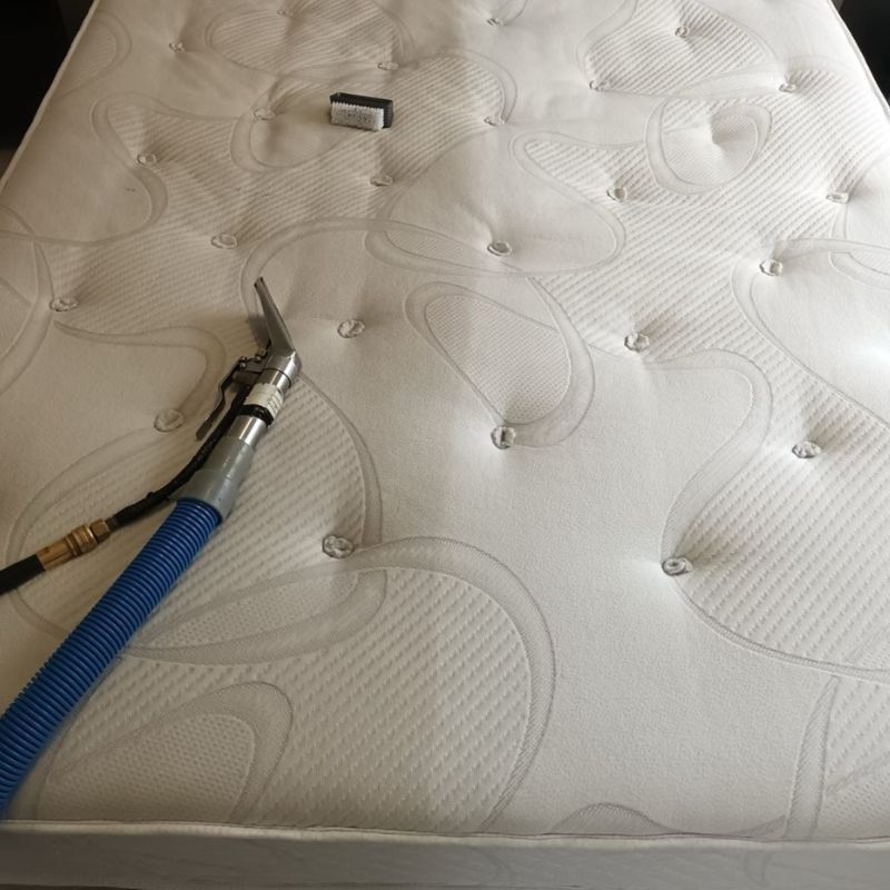 A white mattress with a blue hose attached to it