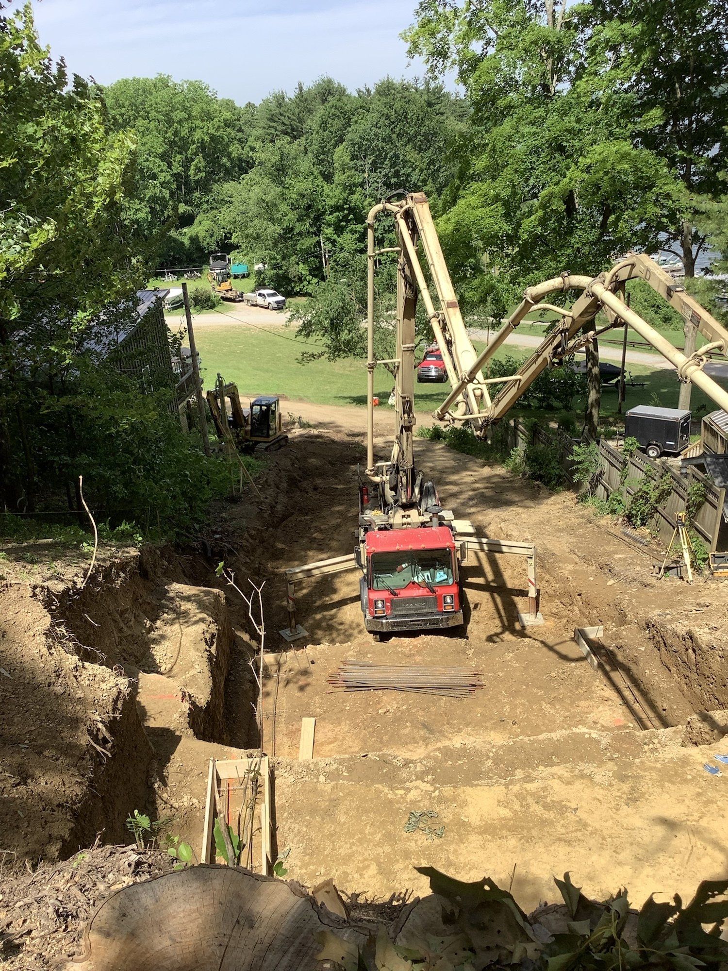Shrock Excavating foundation prep: pouring concrete into a trench via pump truck for a new building.