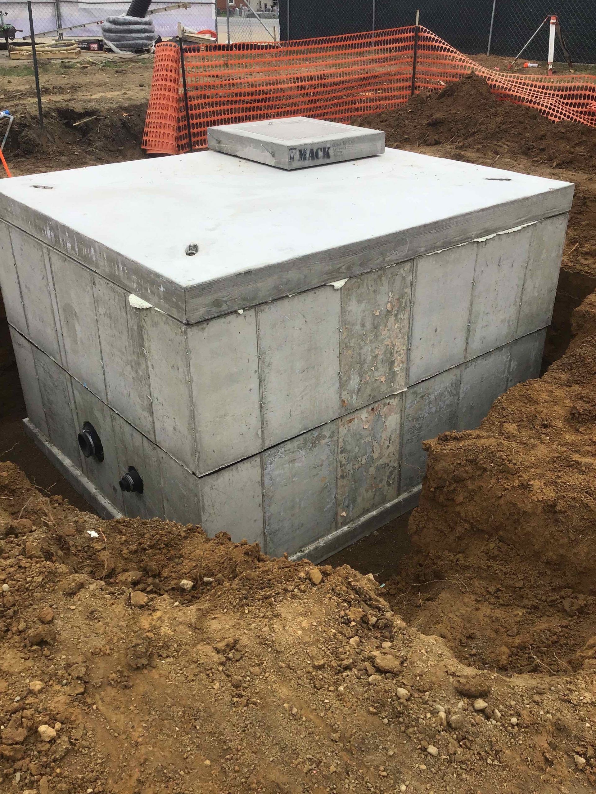 Concrete rectangular septic tank in an excavation pit, construction site.