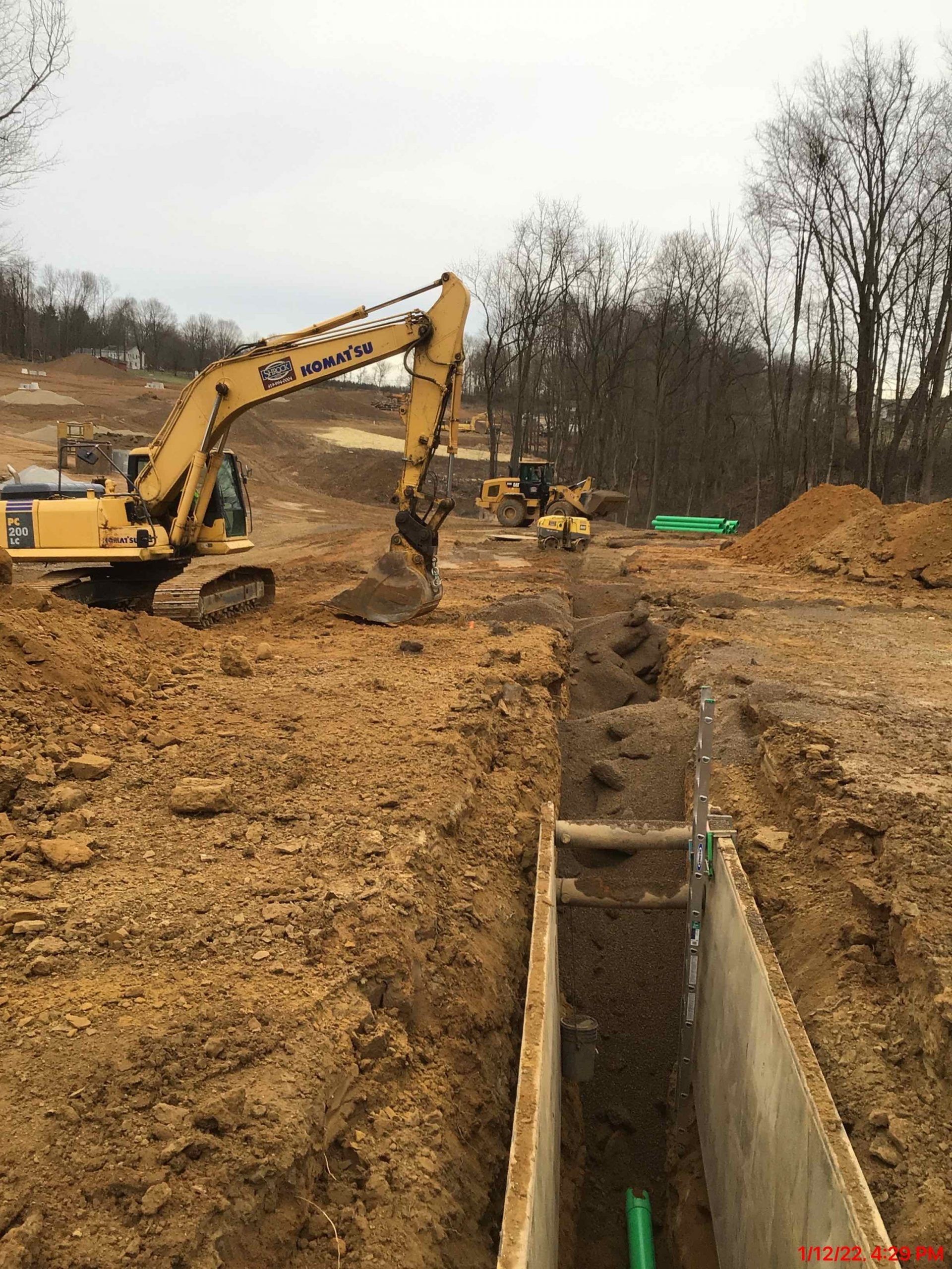 Shrock Excavating dump truck unloading material on a winter site. Year-round site development and hauling.