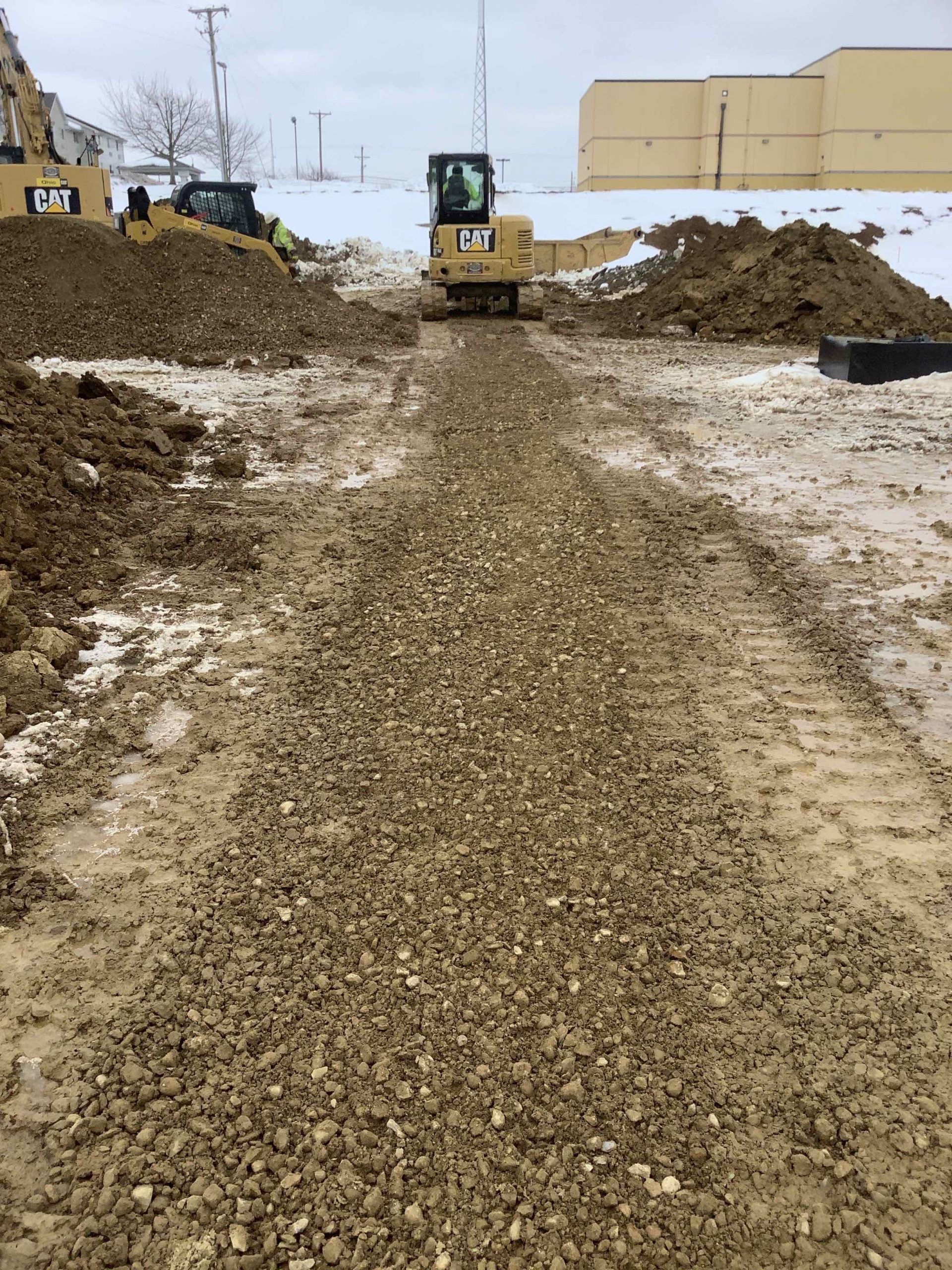 Construction site with gravel path and heavy machinery.