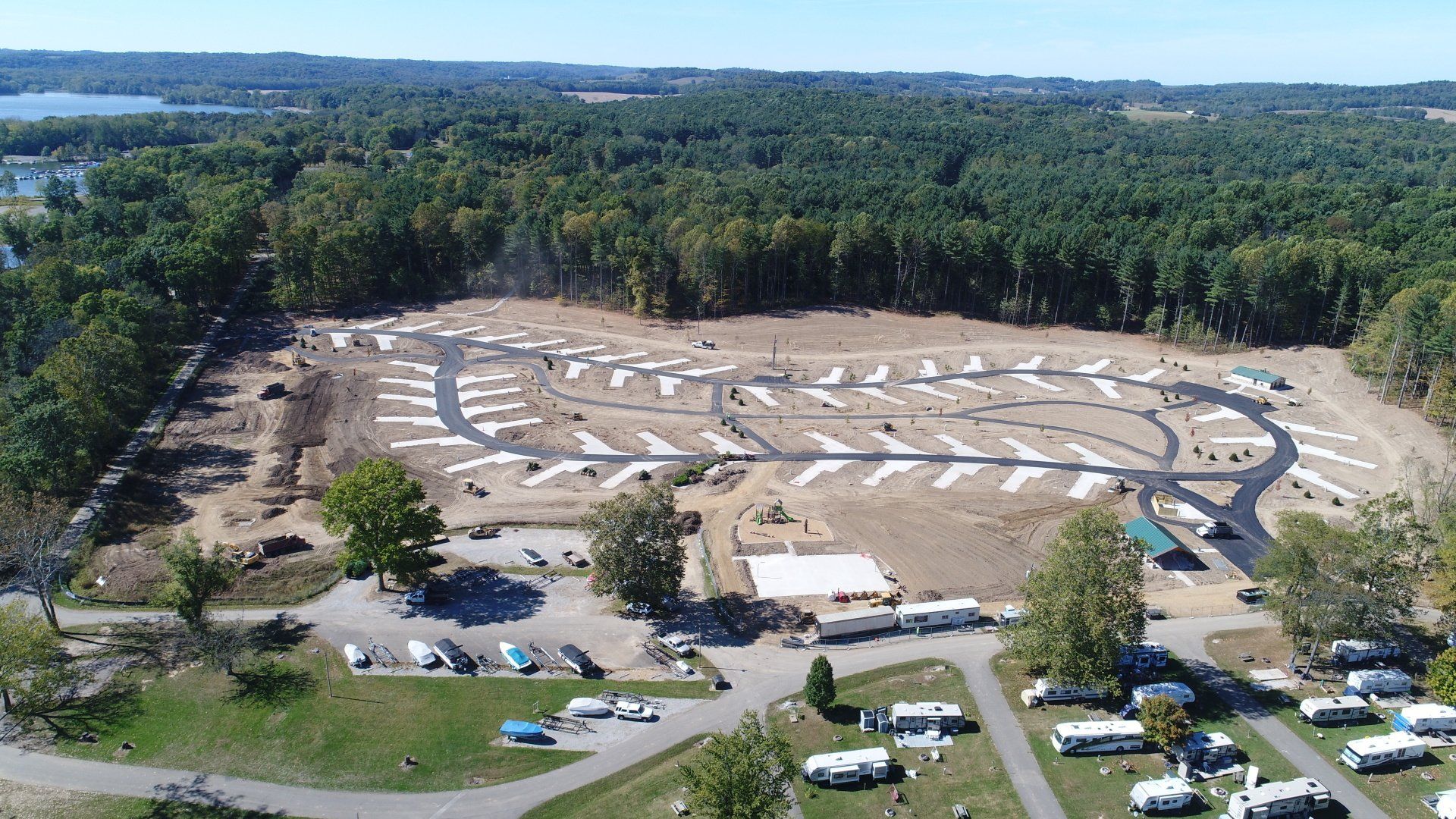 Aerial view of a campground with RVs, trees, and roads.