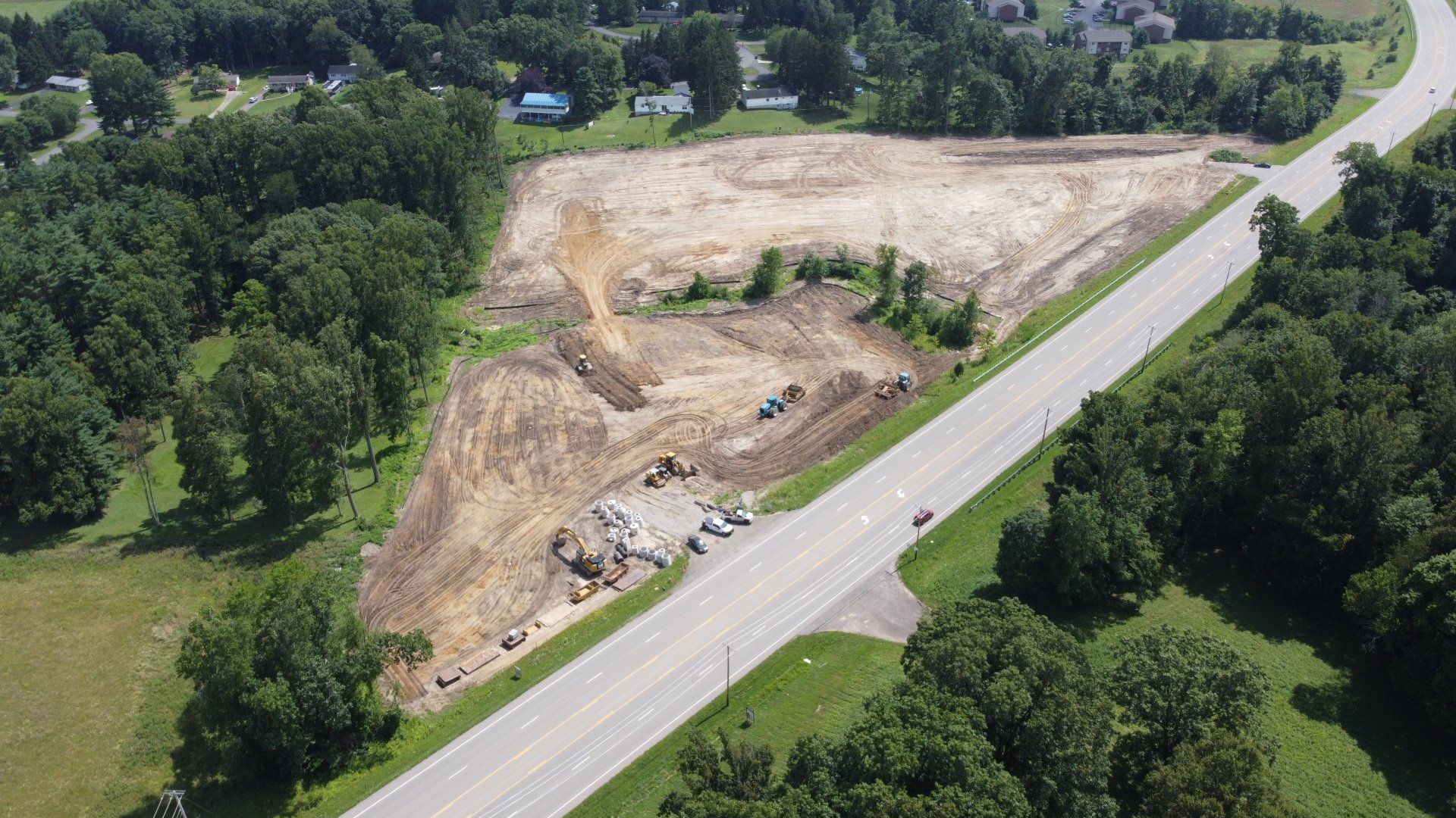Cleared lot next to highway, trees on sides.