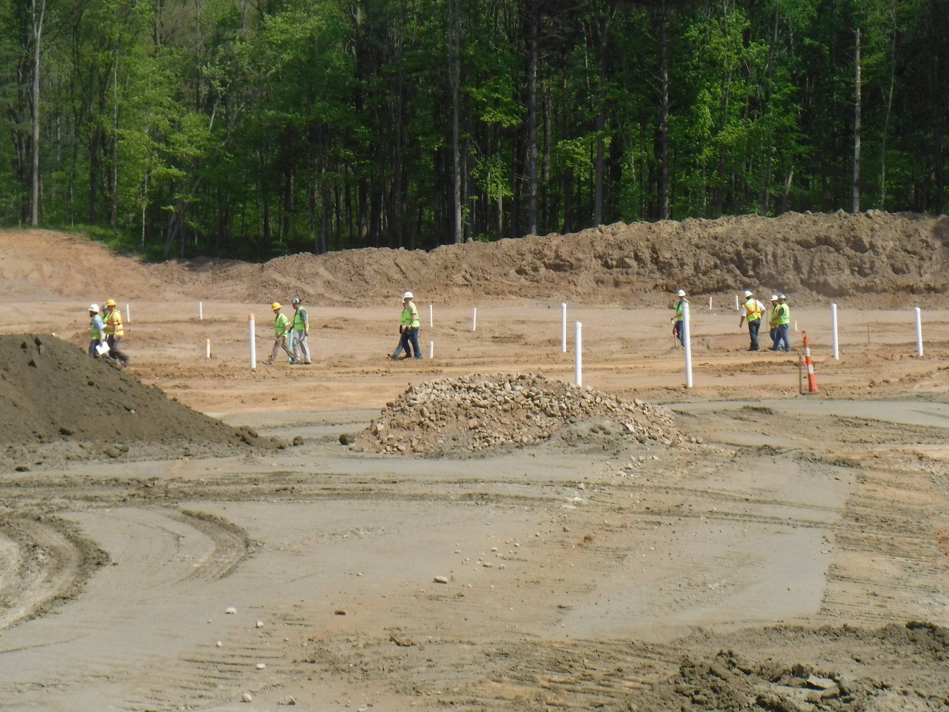 Shrock Excavating team surveying a new home site with stakes and dirt piles. Professional site prep in Ohio.