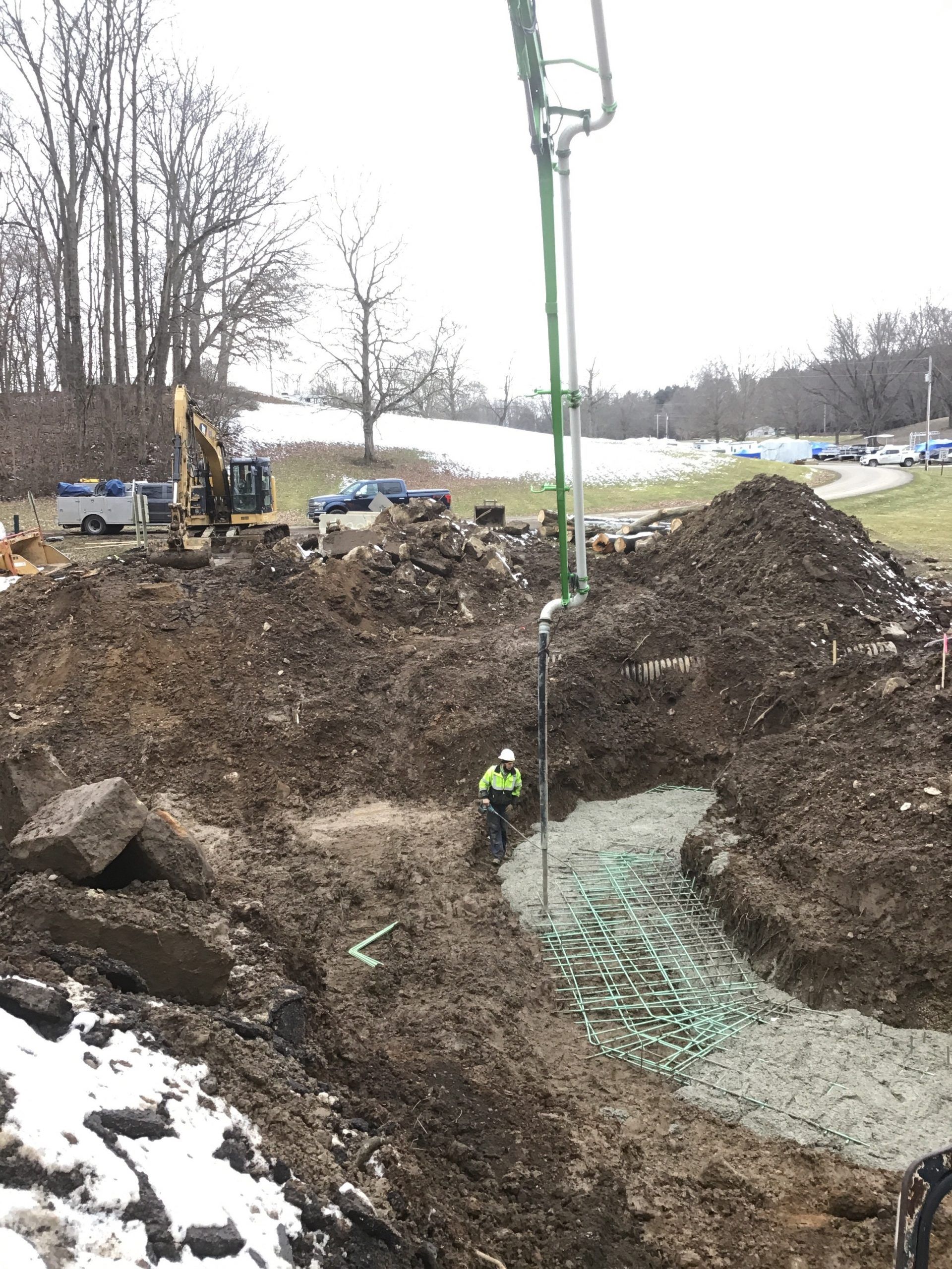 Shrock Excavating winter site prep: pumping concrete for a new foundation on a snow-covered Ohio site.