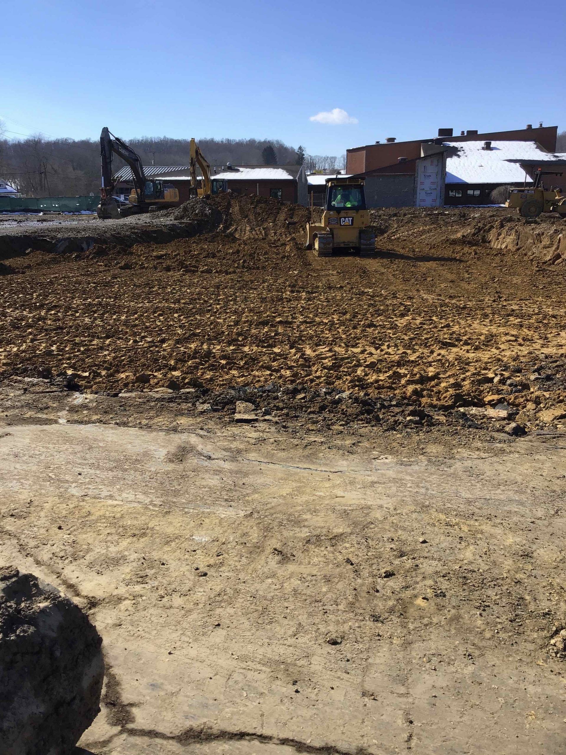 Construction site with heavy equipment, clear blue sky.