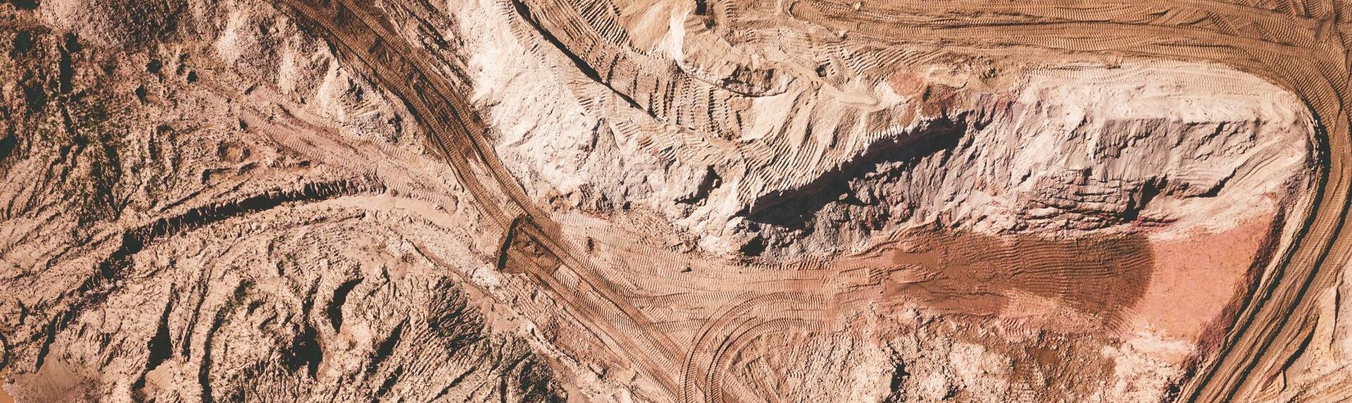 Aerial view of a brown and white sand formation in a desert-like environment.