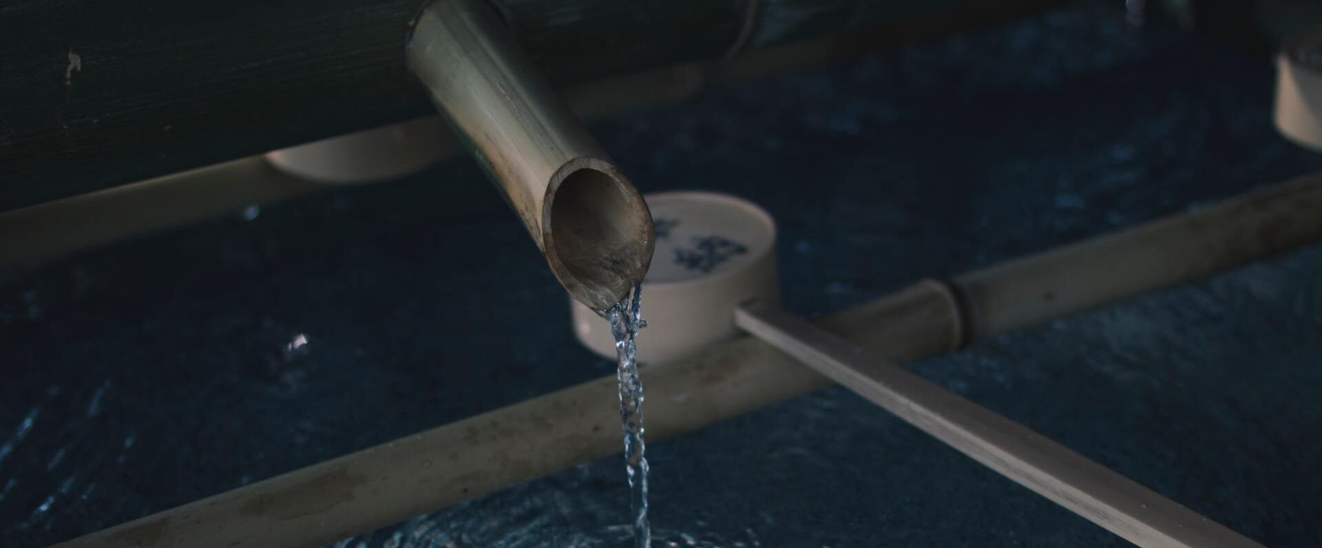 Water flows from a spout into a stone basin.