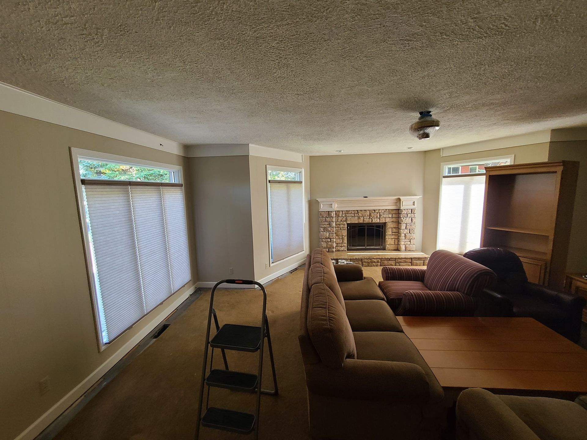 A living room with a couch , chair , table and fireplace.