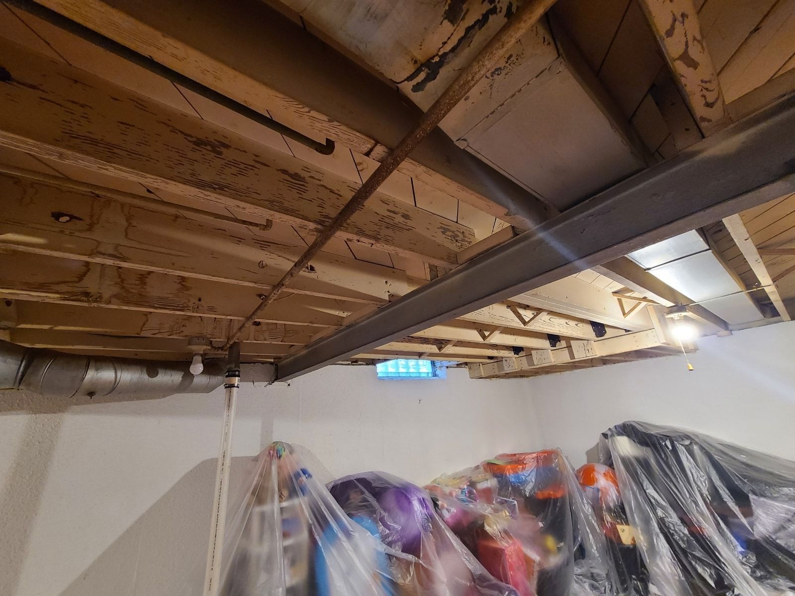 The ceiling of a basement is being remodeled and covered in plastic.