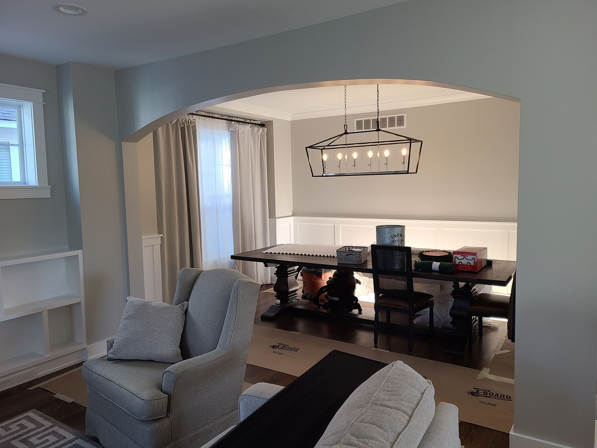 A living room with a couch , chair , table and chandelier.