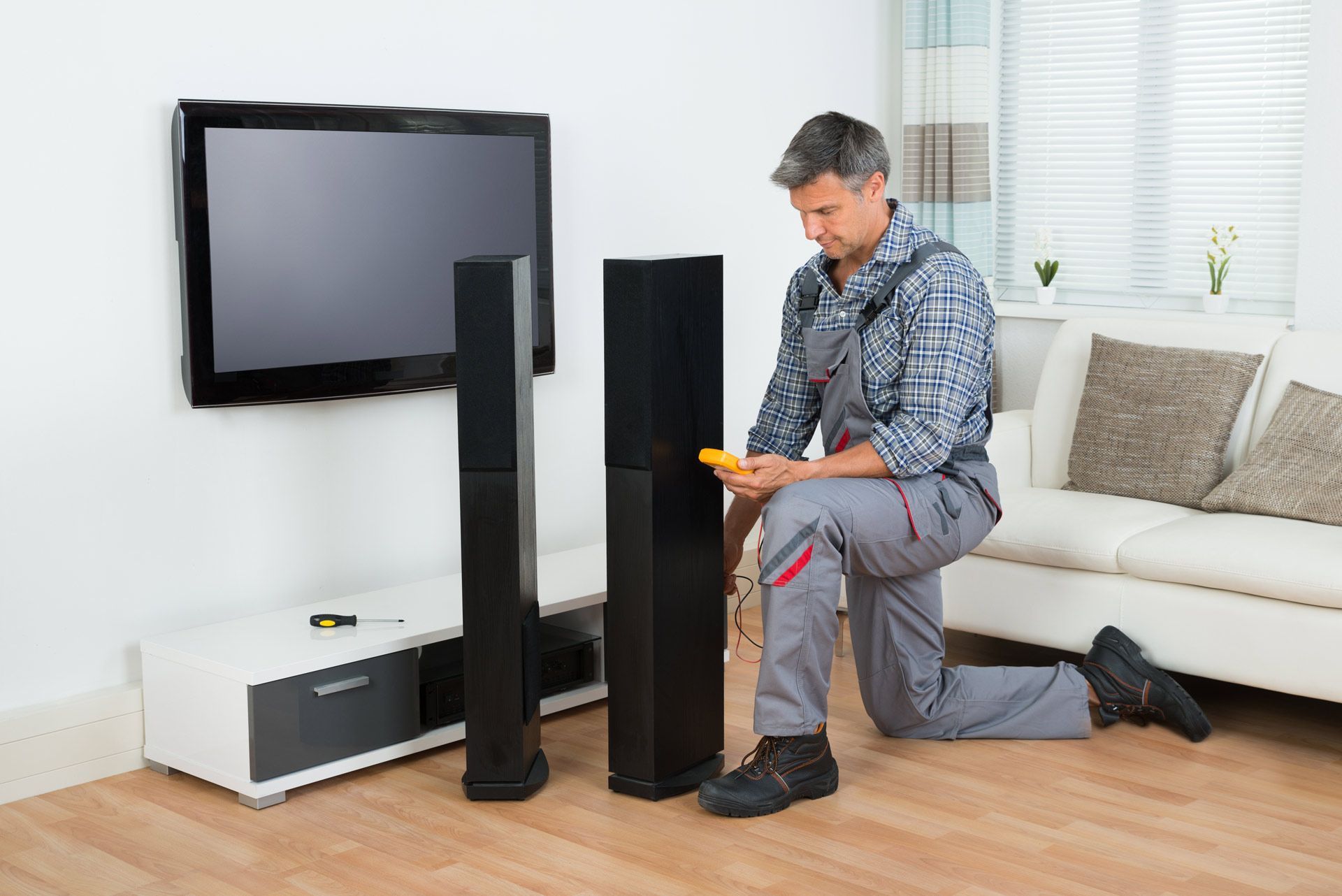 Full Length of Technician Checking TV Speaker with Multimeter at Home | Mildura, Vic | a & R Electronics