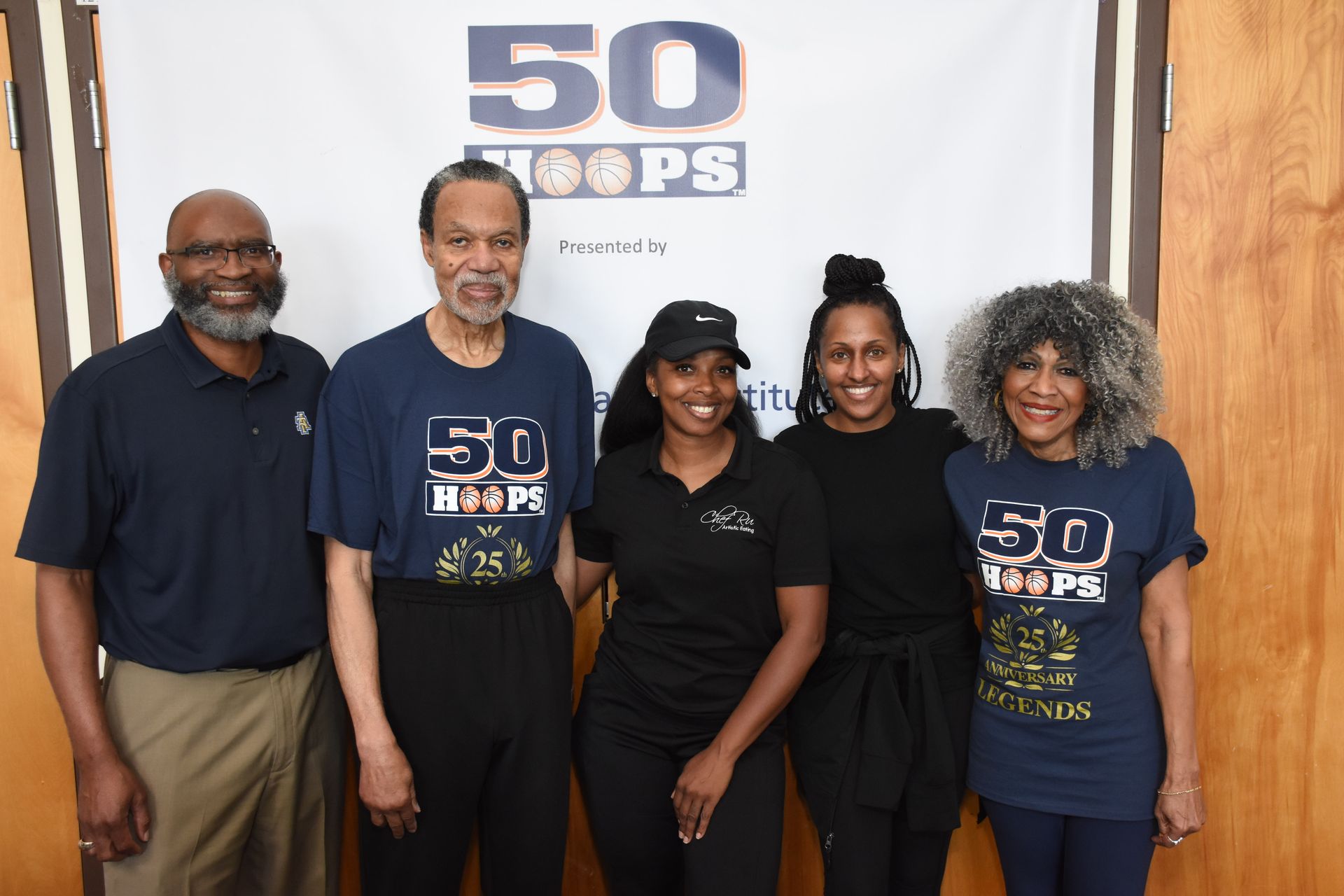 Group of five people in front of a banner that says 