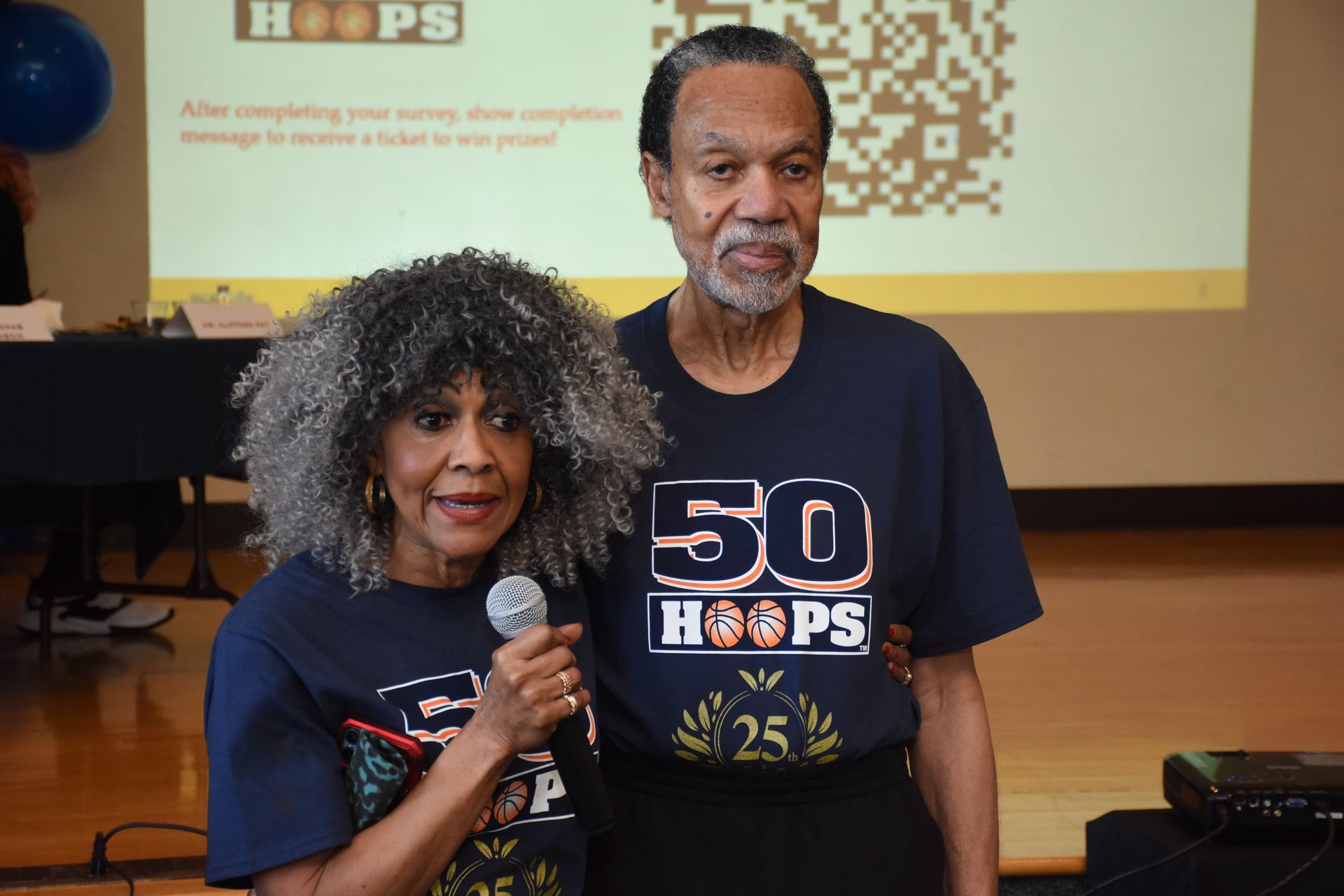 Woman with microphone and man wearing matching 
