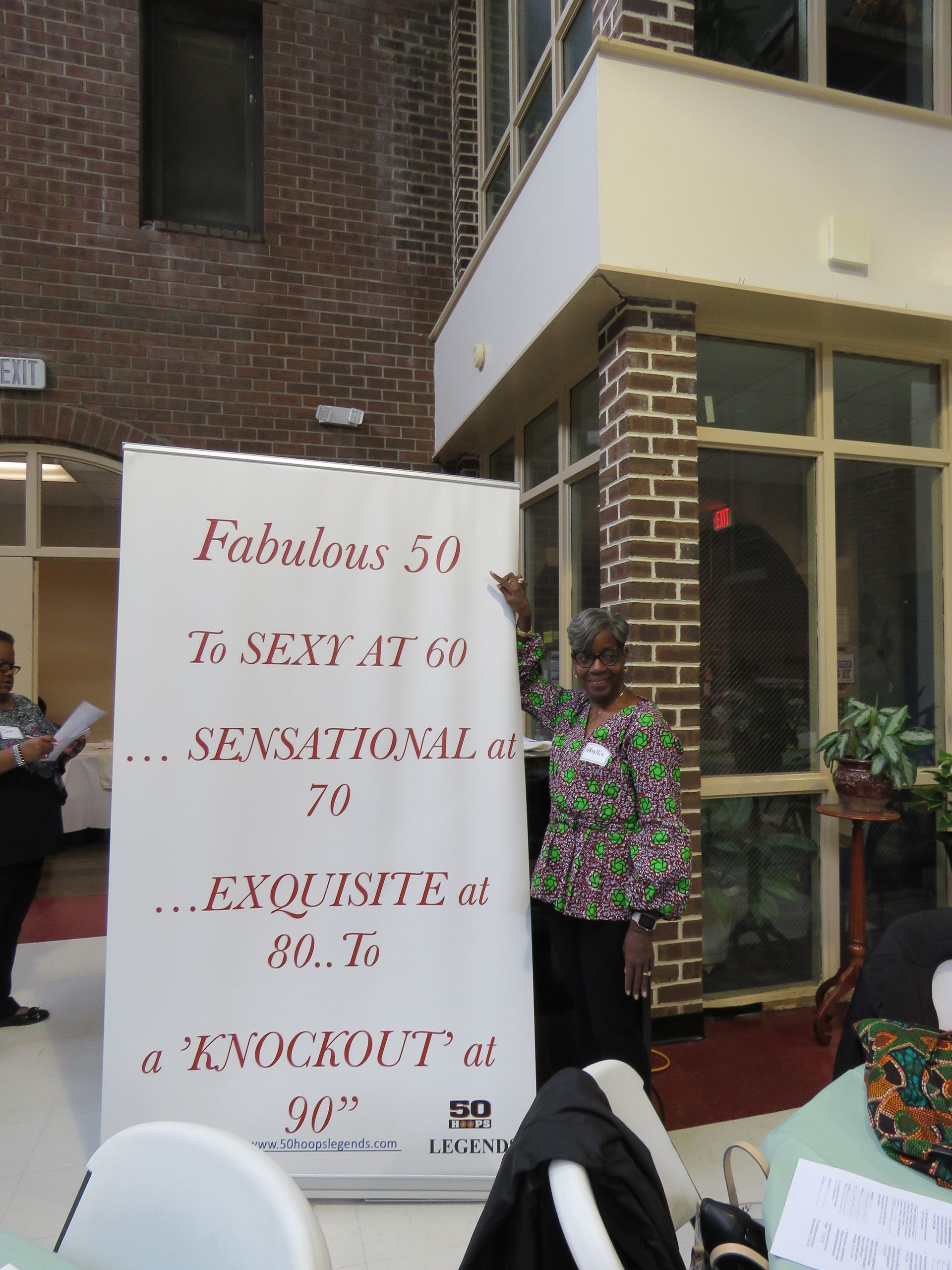 Woman stands near a banner