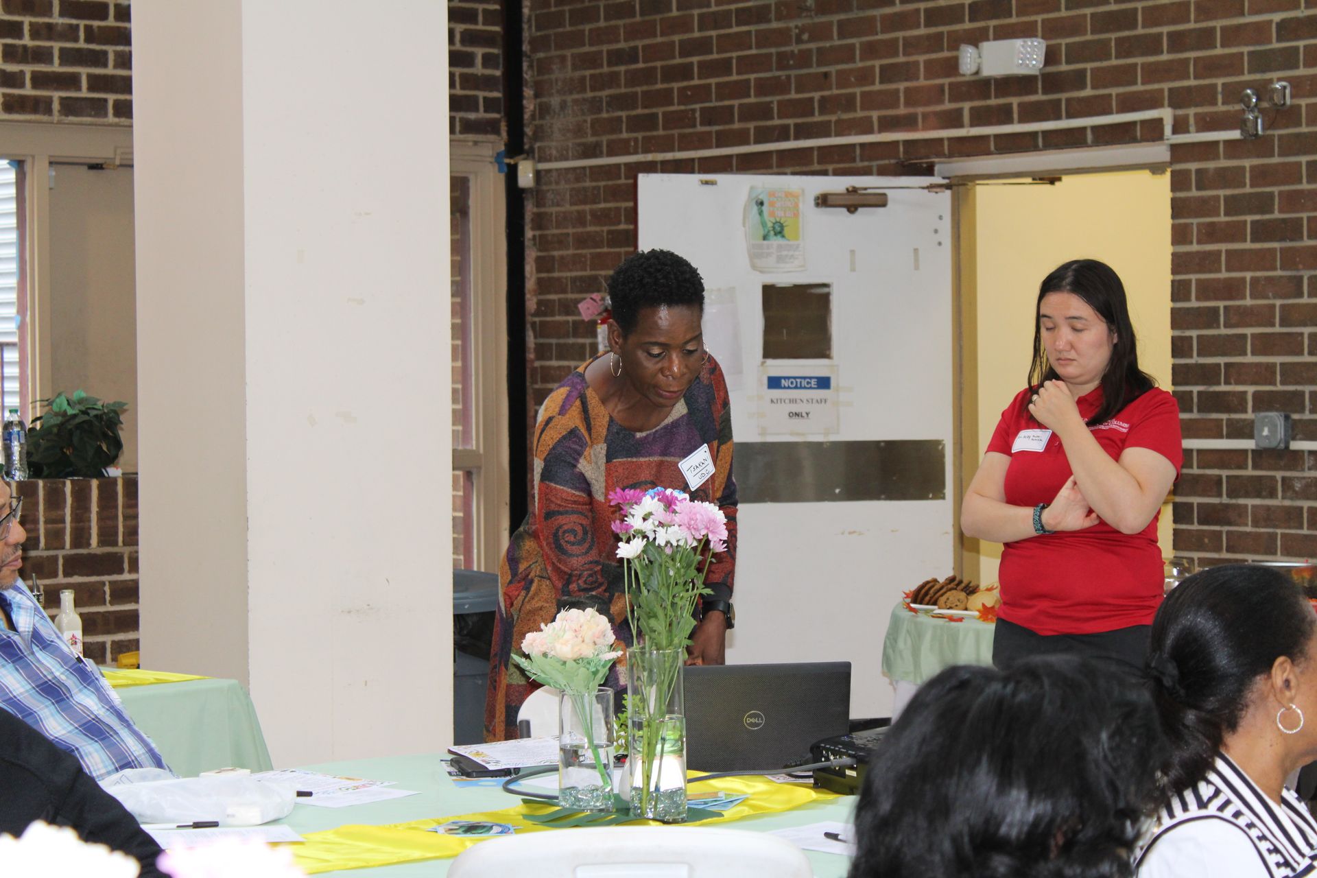 Two women at a table with flowers