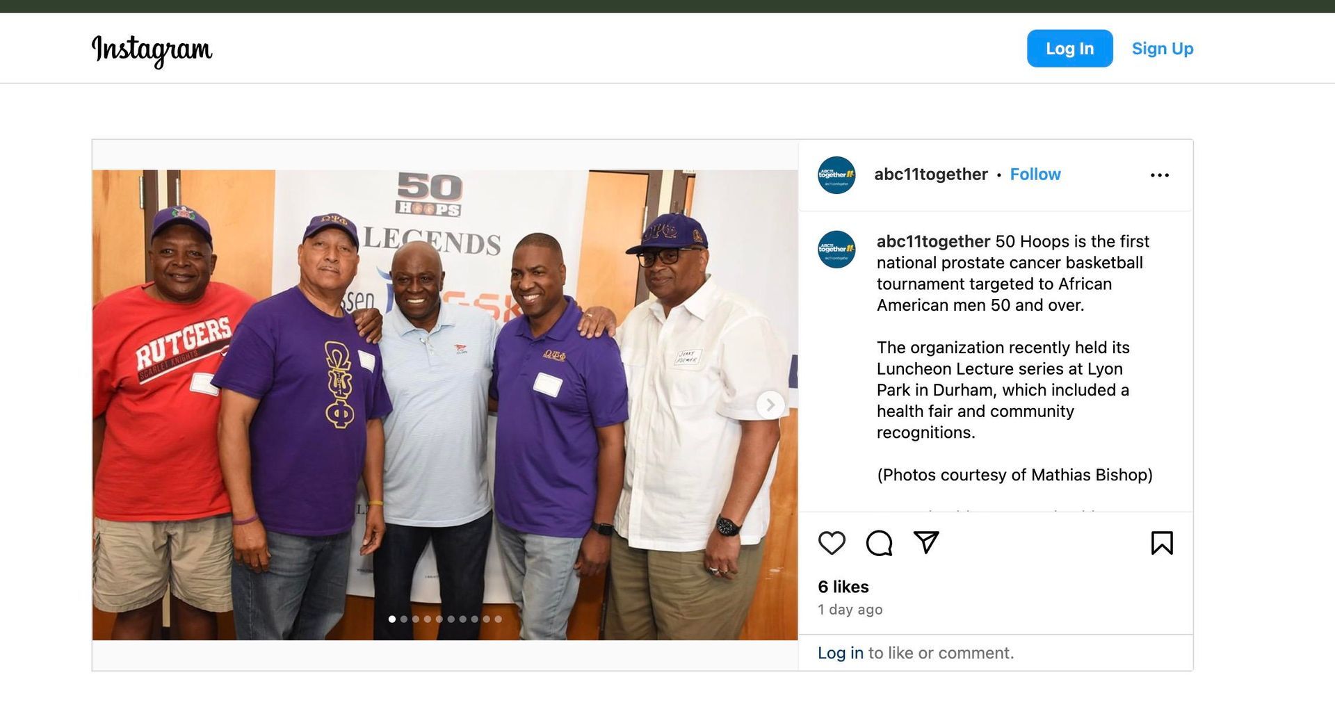 Five men posing together, some wearing purple shirts, at a 