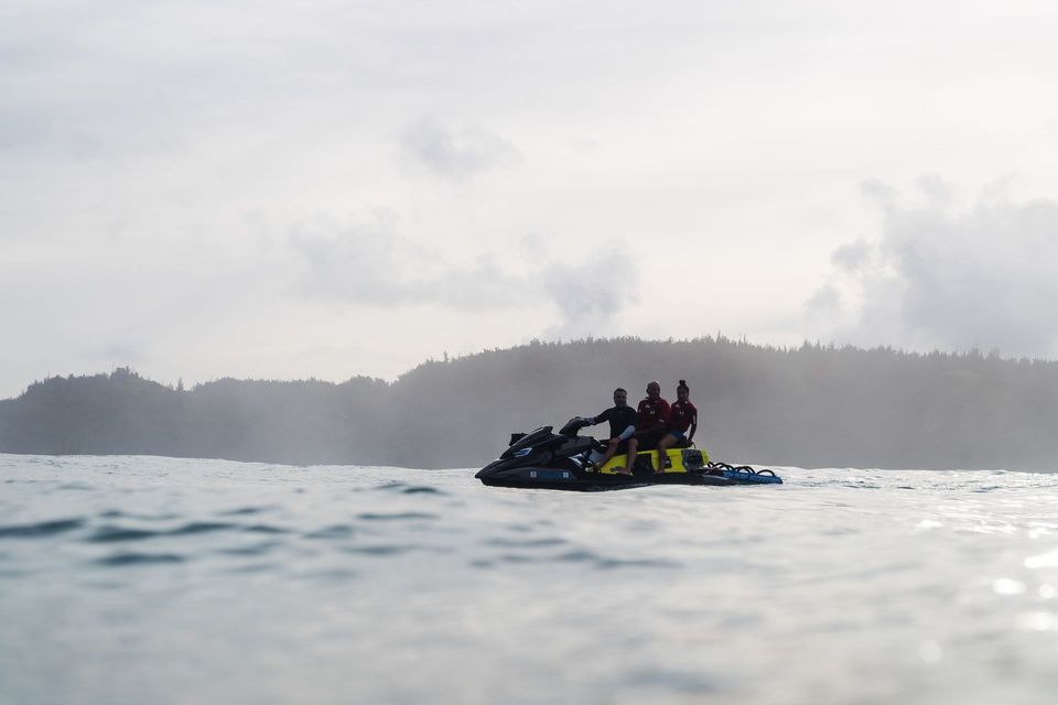 Group riding a jet ski on choppy water with a misty island in the background