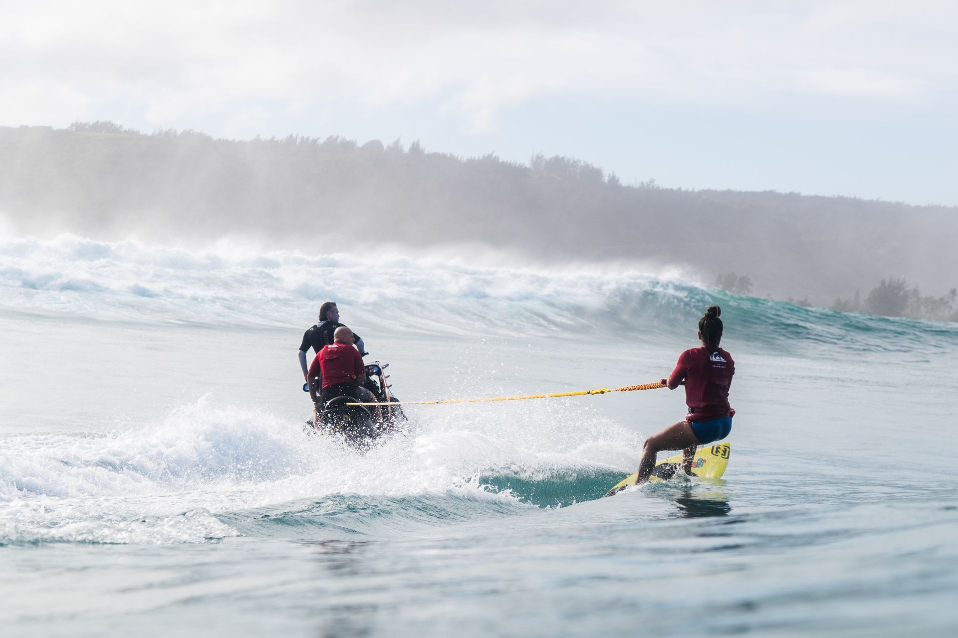 Two people on a red-and-blue jet ski riding on open water