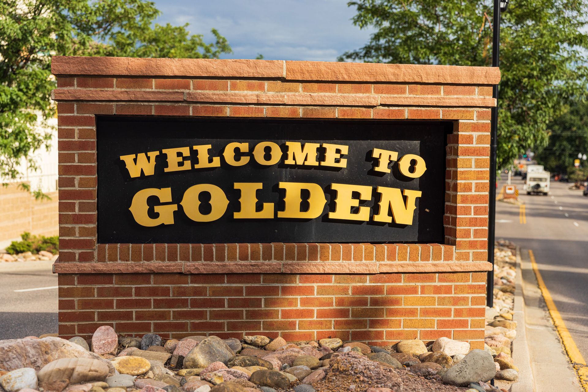 A welcome to golden sign on a brick wall