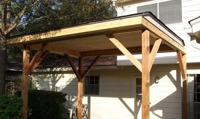 A wooden structure is sitting on the side of a house.