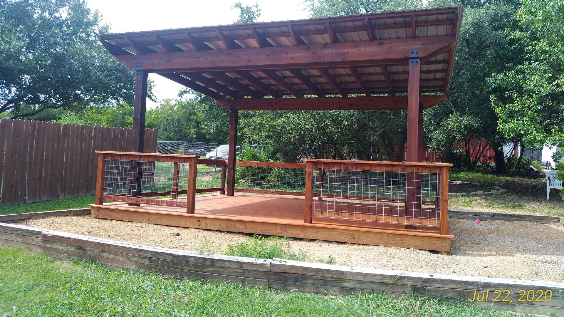 A wooden deck with a pergola in the backyard