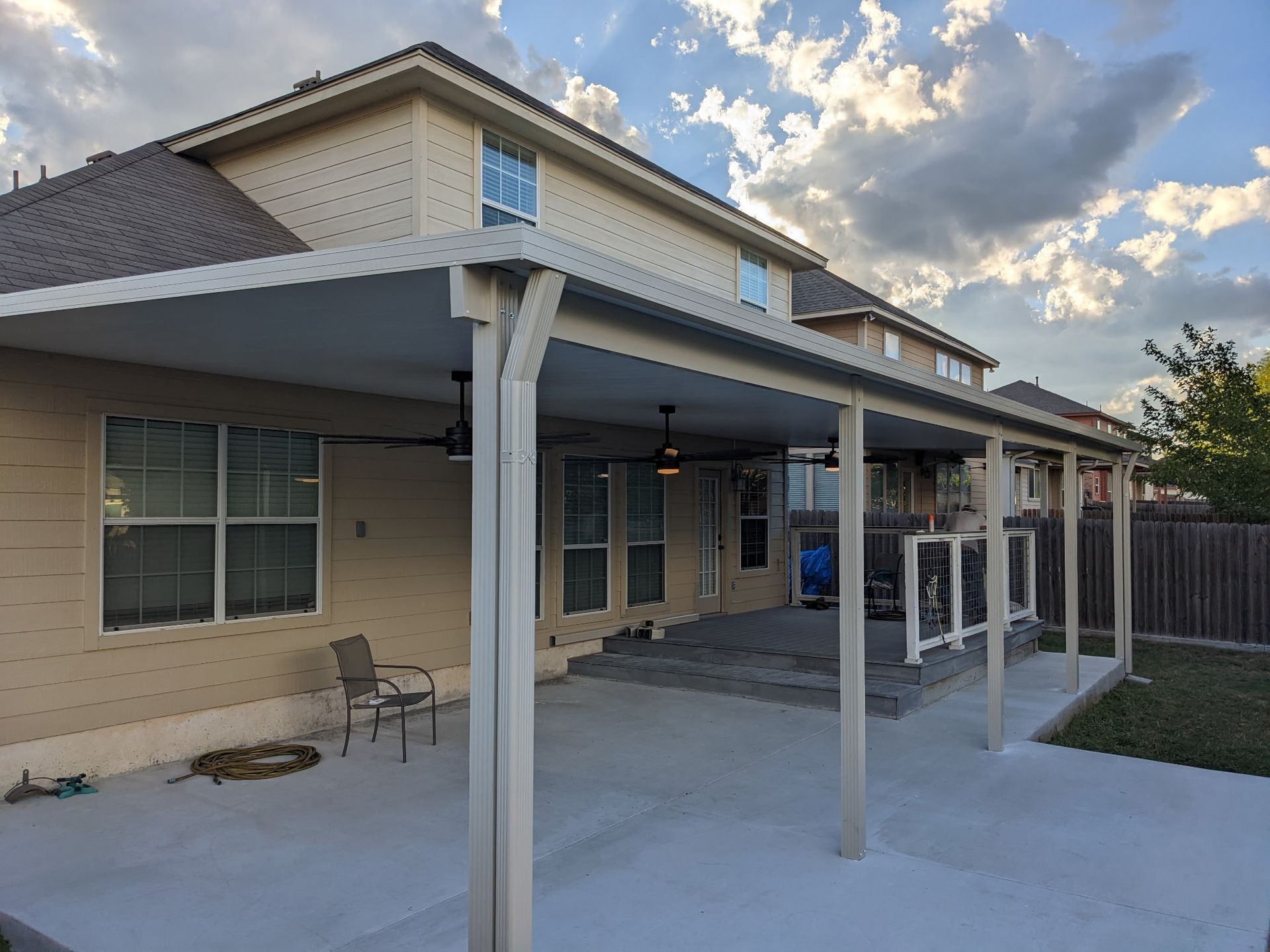 A large house with a covered patio in front of it.