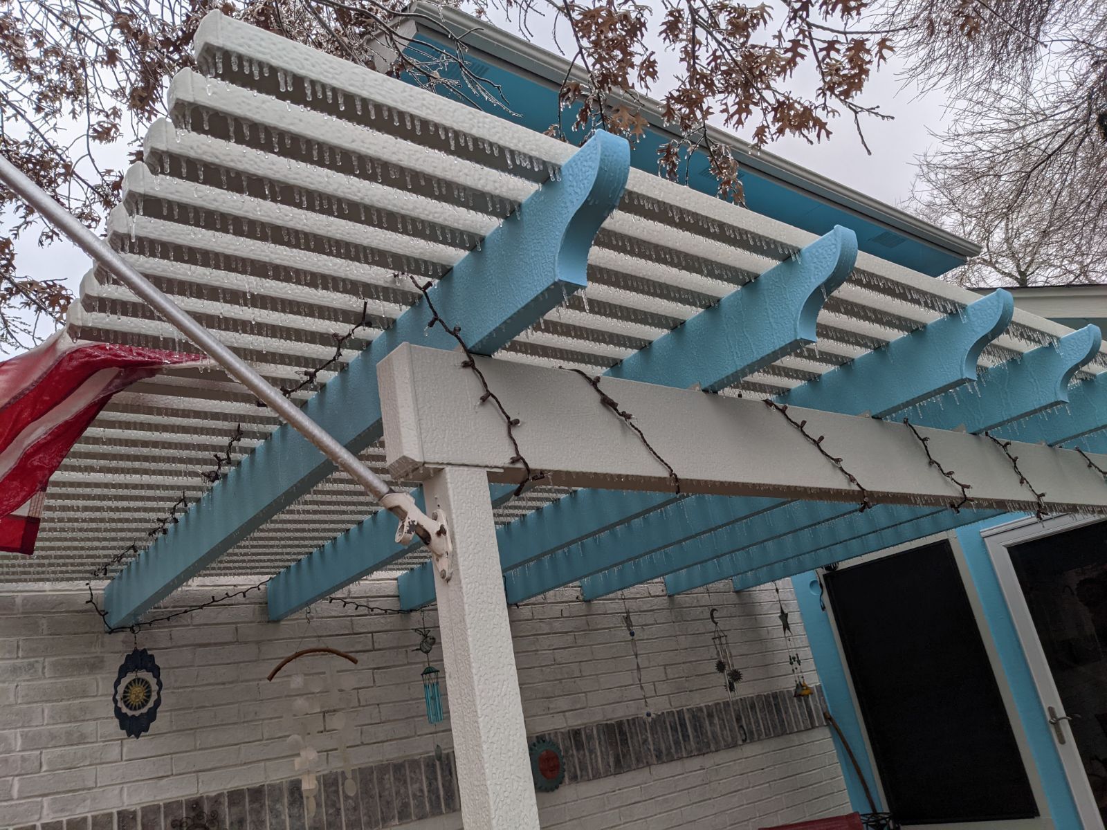 A blue and white pergola is sitting on top of a brick building.