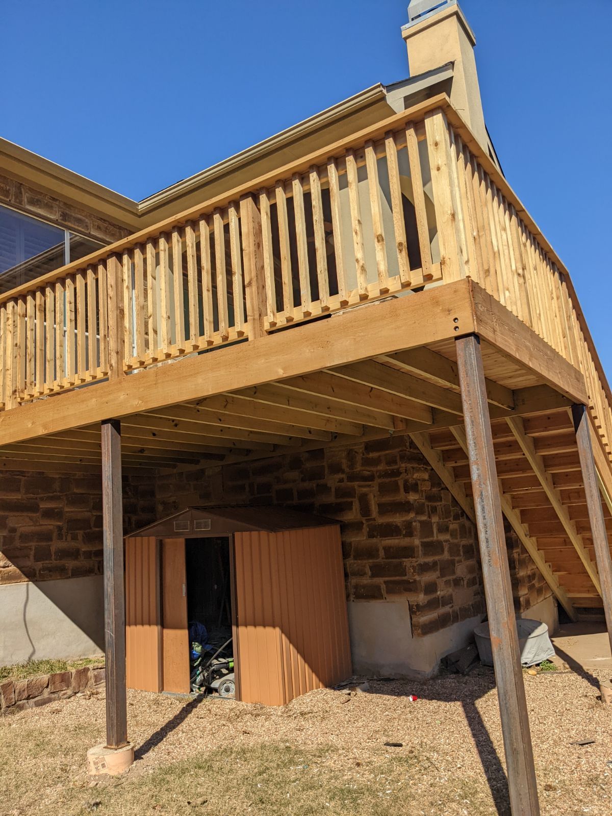 A wooden deck is sitting on top of a brick building.