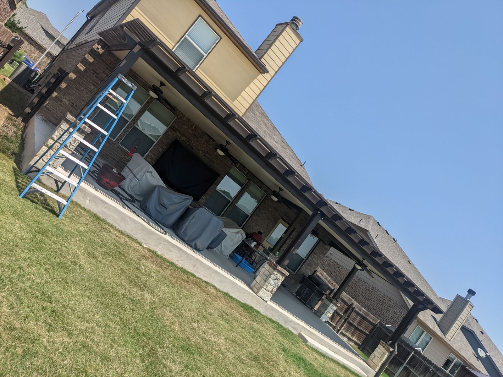 A pergola is being built in the backyard of a house.