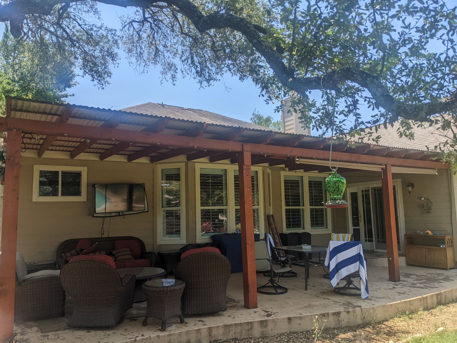 There is a patio with a pergola and a lot of furniture on it.