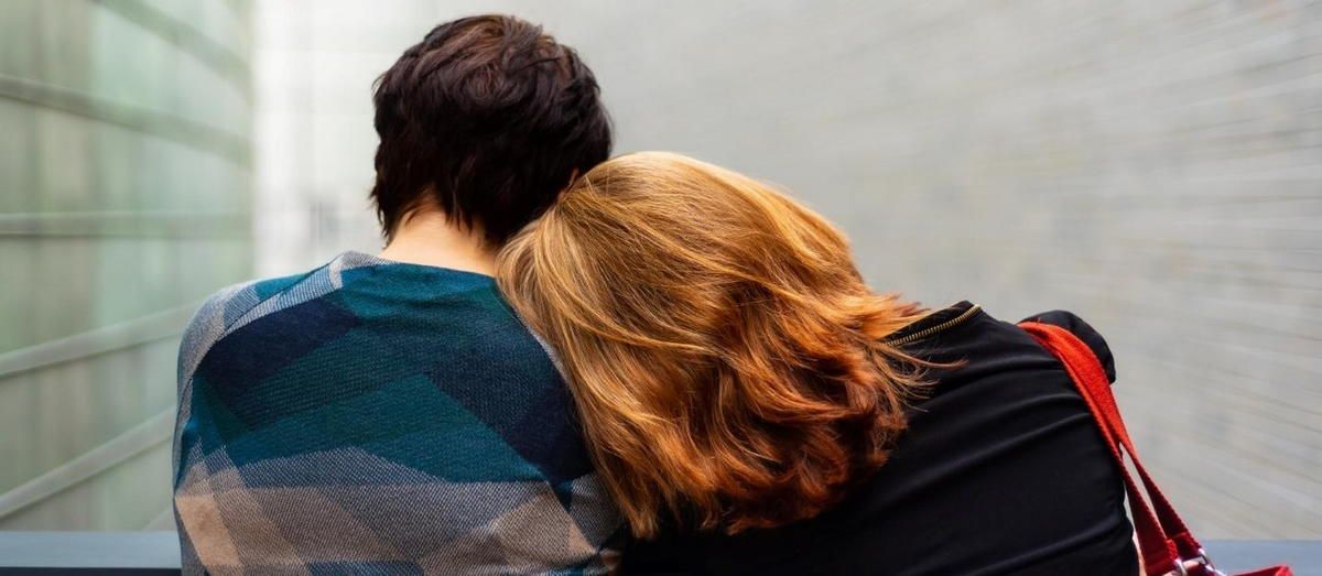 A man and a woman are sitting next to each other on a bench. A man and a woman are sitting next to each other on a bench.