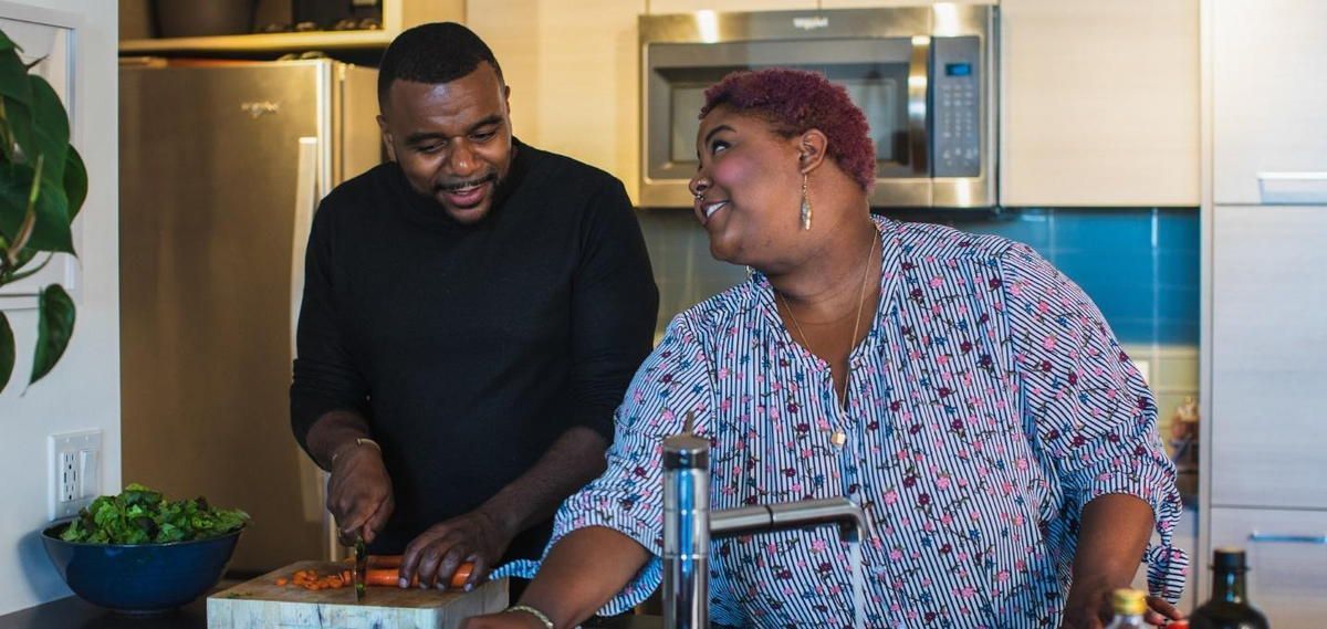 A man and a woman are cooking together in a kitchen. A man and a woman are cooking together in a kitchen.