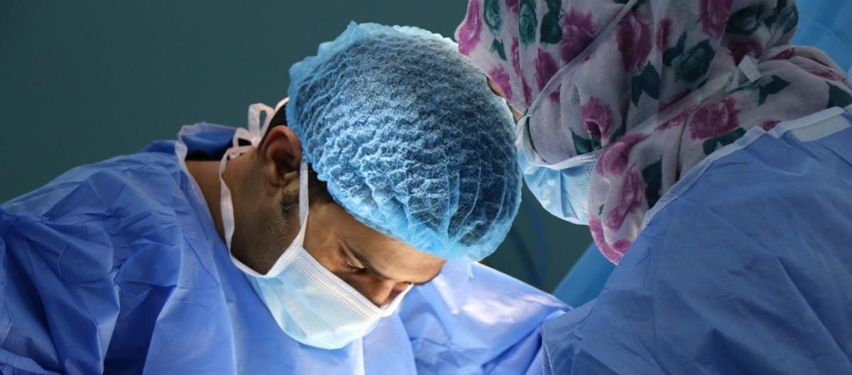 A surgeon is operating on a patient in an operating room. A surgeon is operating on a patient in an operating room.