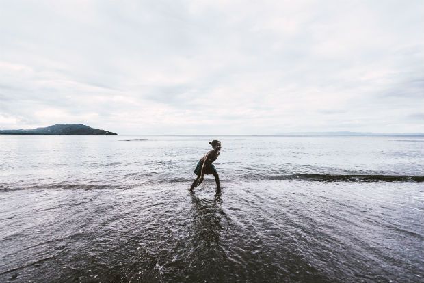 A person is walking on a beach near the ocean. A person is walking on a beach near the ocean.