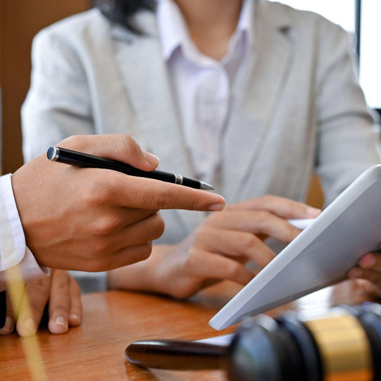 A man is pointing at a tablet while a woman looks on. A man is pointing at a tablet while a woman looks on.