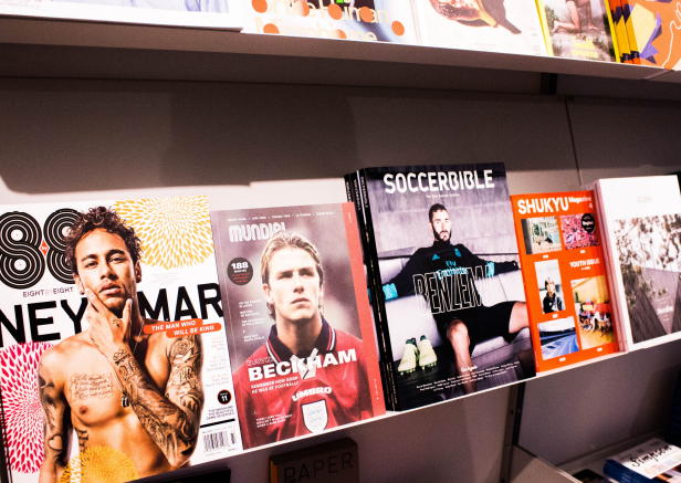 A shelf filled with magazines including soccerbible and neymar A shelf filled with magazines including soccerbible and neymar
