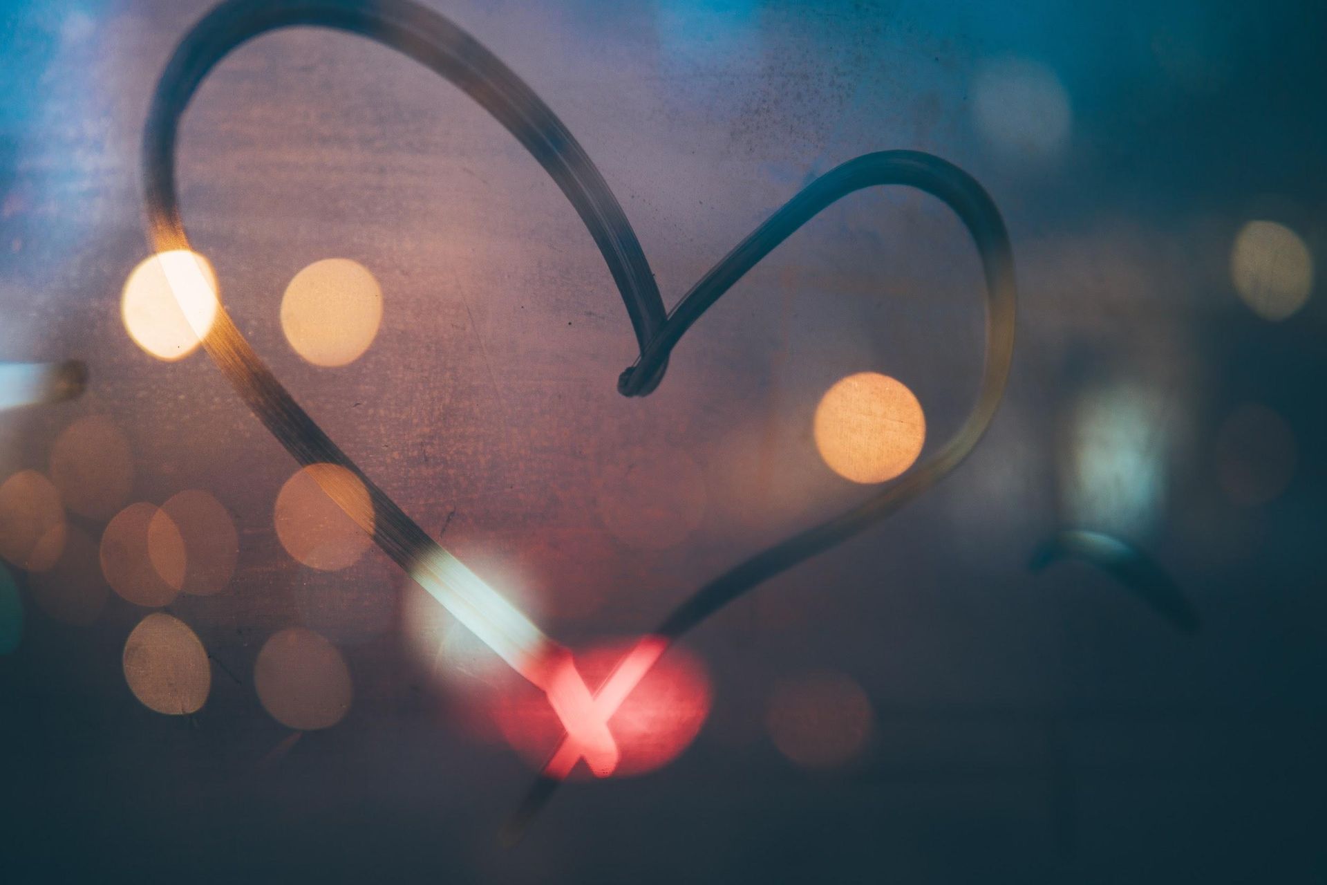 A heart is drawn on a window with a blurry background. A heart is drawn on a window with a blurry background.