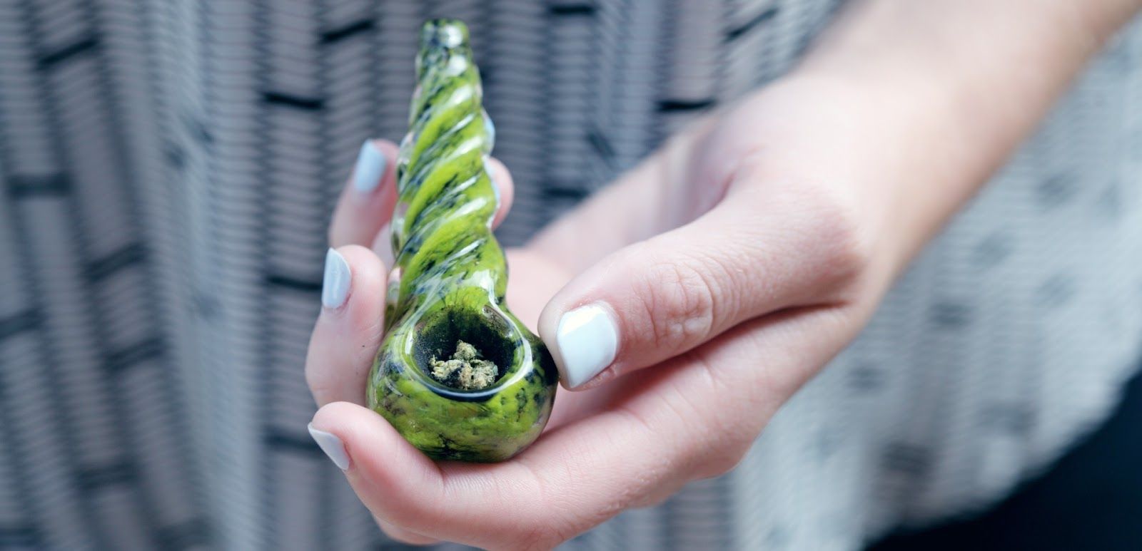 A woman is holding a green pipe in her hand. A woman is holding a green pipe in her hand.