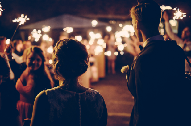 A bride and groom are holding sparklers at a wedding reception. A bride and groom are holding sparklers at a wedding reception.