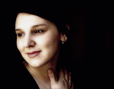 A close up of a woman 's face with a black background.