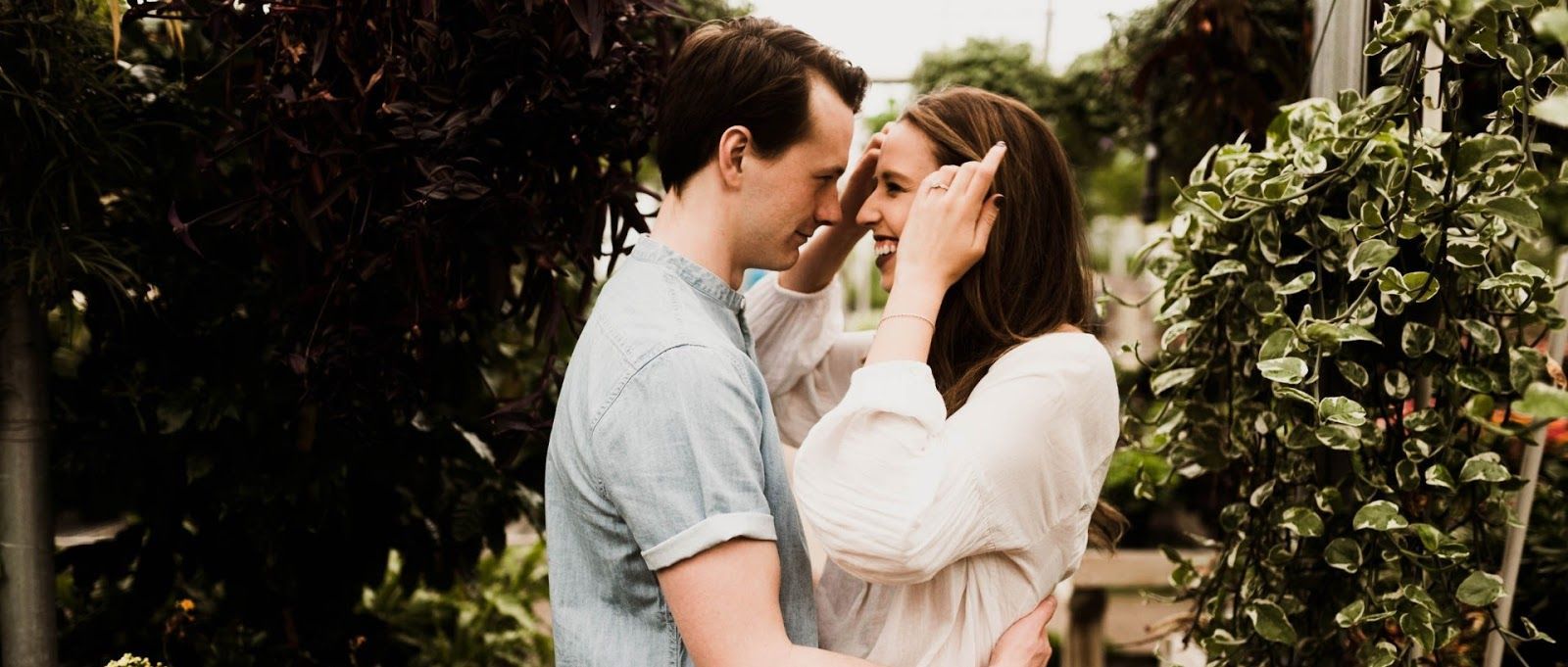 A man and a woman are hugging each other in a garden.